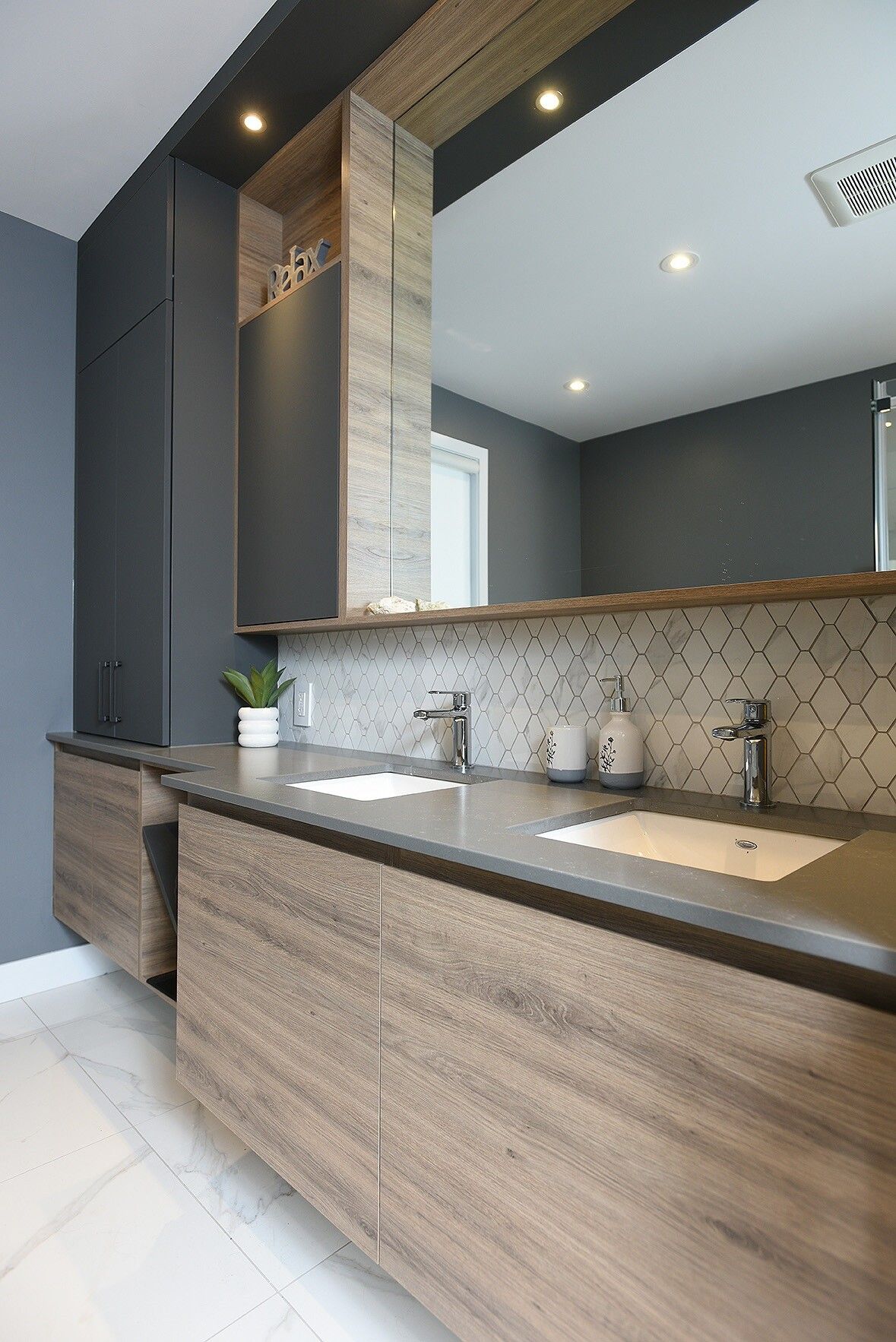 Une salle de bain avec lavabo, miroir et armoires en bois.