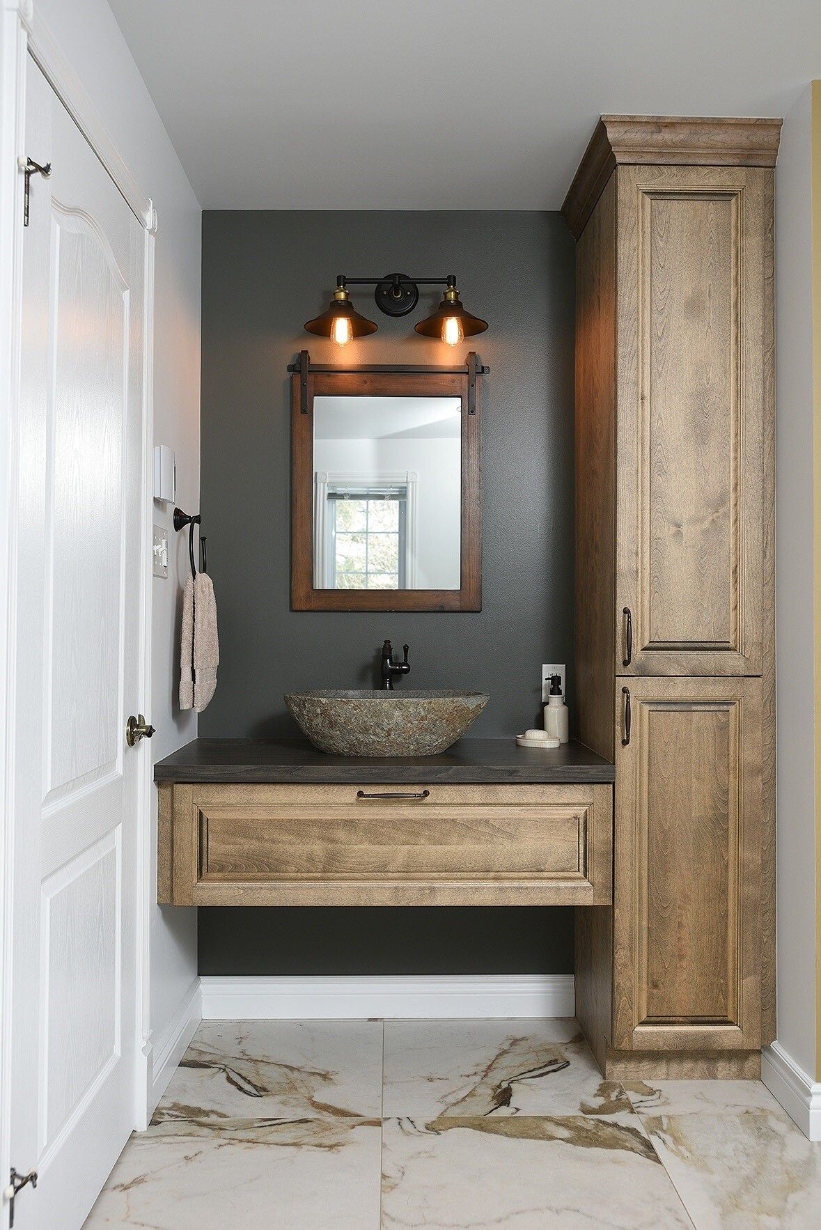Une salle de bain avec un lavabo, un miroir et des armoires.