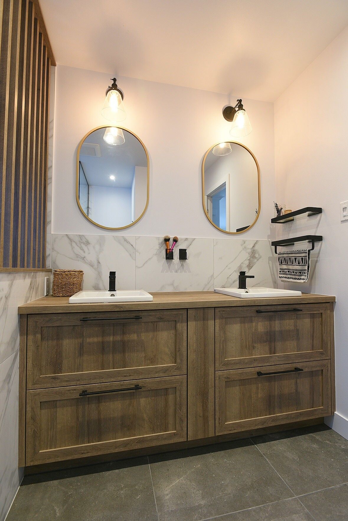 Une salle de bain avec deux lavabos et deux miroirs.