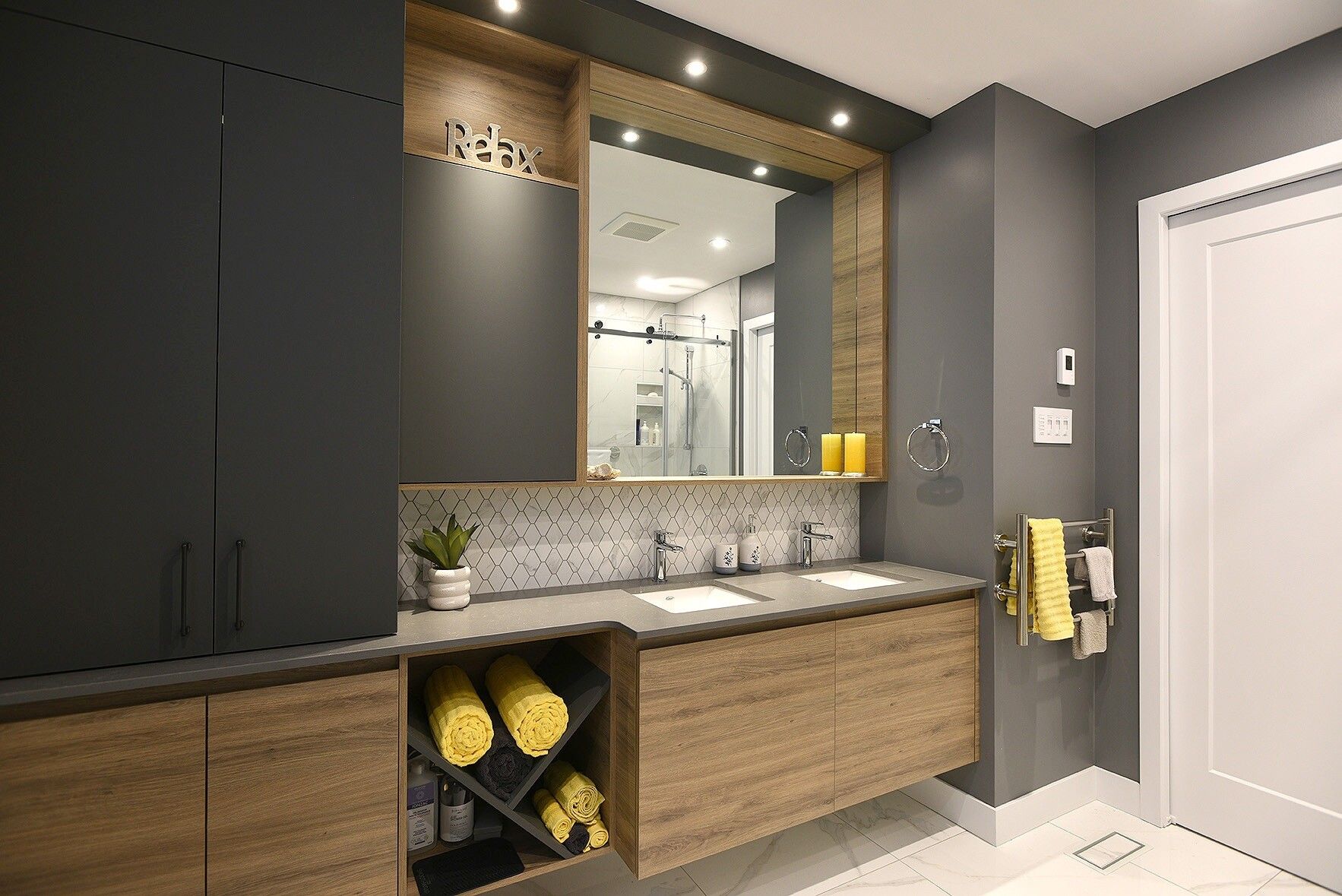 Une salle de bain avec deux lavabos et un grand miroir.