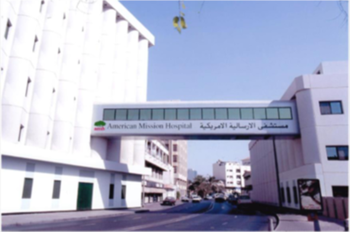 A bridge between two buildings that says american mission hospital