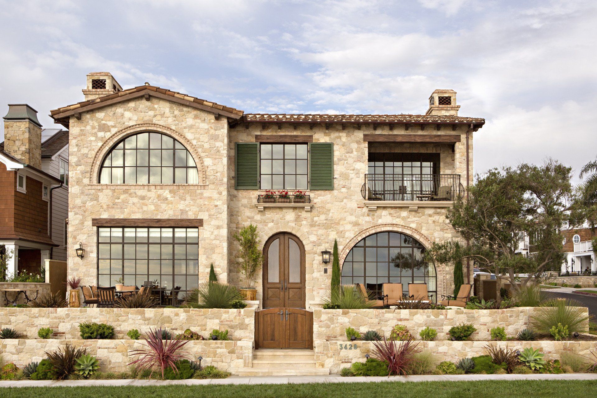 Exterior of a Tuscan stone villa in Corona Del Mar designed by Oatman Architects