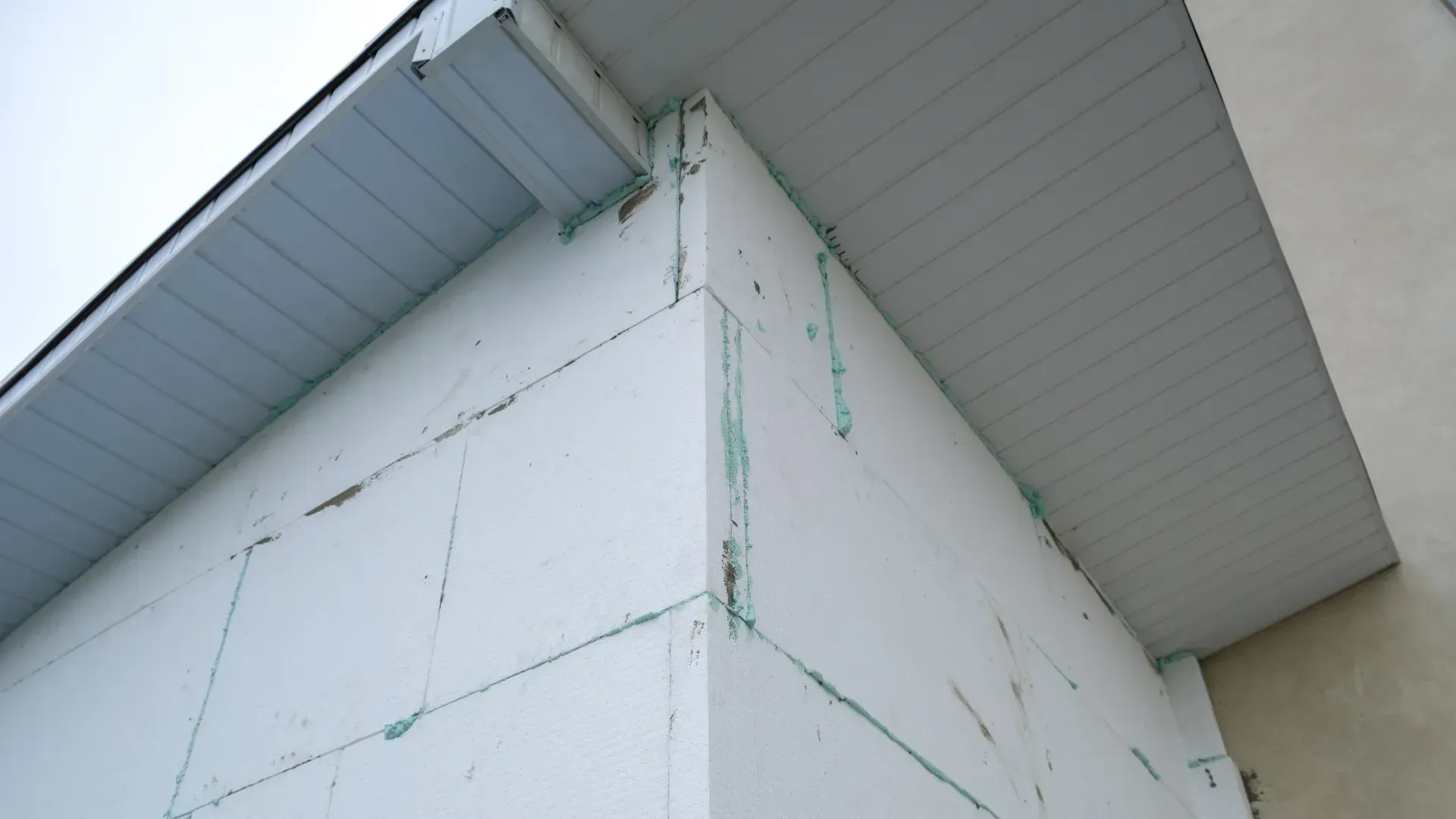 A white building with a white roof and a white gutter.