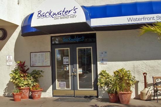 Entrance to Backwaters restaurant with blue awning and potted plants
