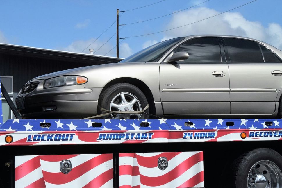 sedan car on a flatbed tow truck