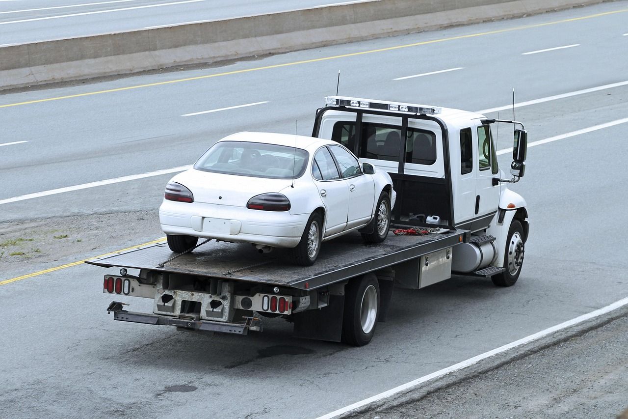 transporting a small car on a flatbed tow truck