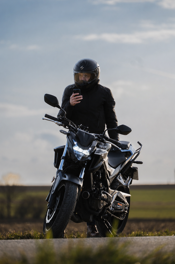 stalled motorcycle driver calling for a tow truck