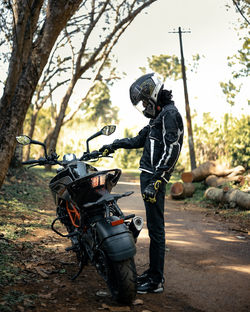 man standing on road with stalled motorcycle needs a tow