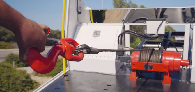 tow truck worker preparing a winch out for a car