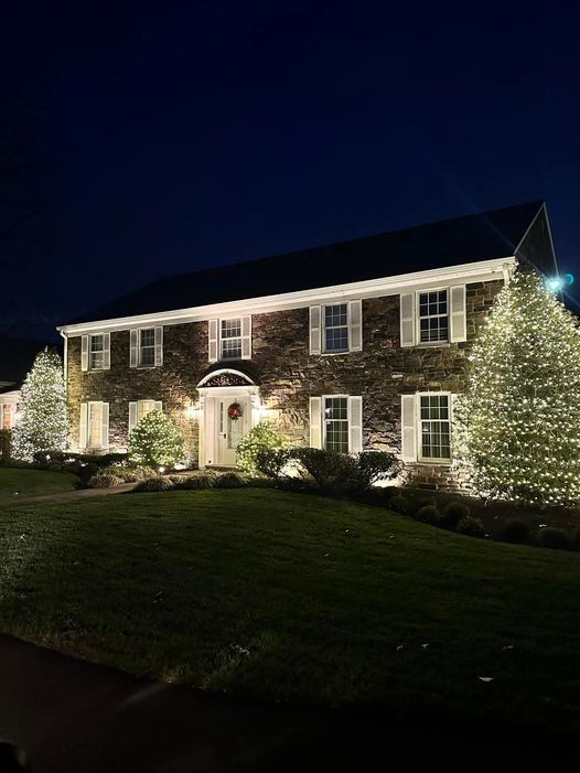 A large house is lit up with christmas lights at night.