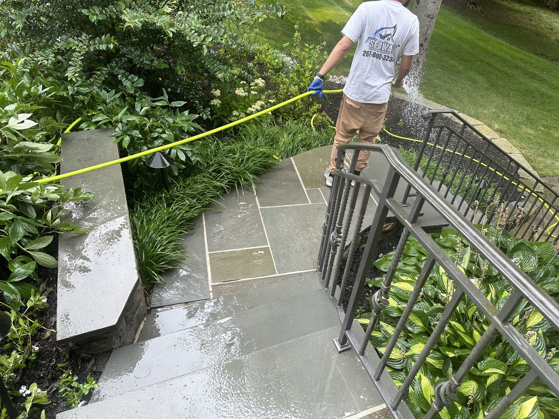 A man is standing on a set of stairs holding a tape measure.