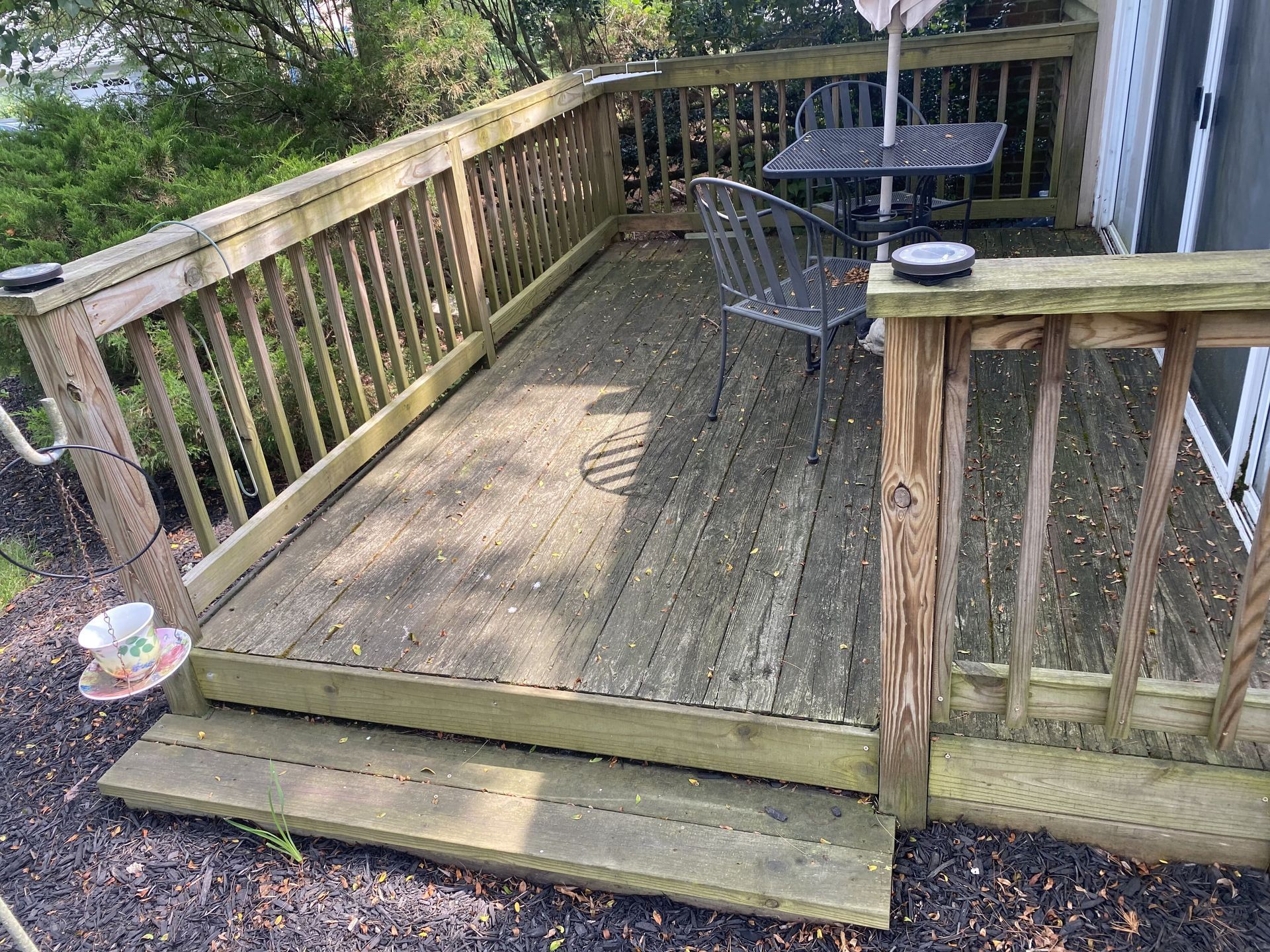 A wooden deck with a table and chairs on it.