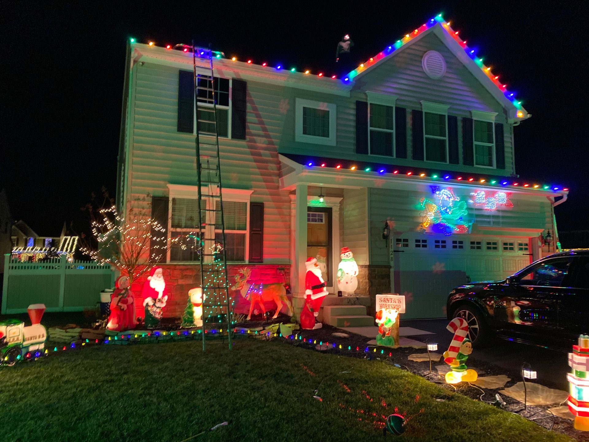 A house is decorated with christmas lights and decorations at night.