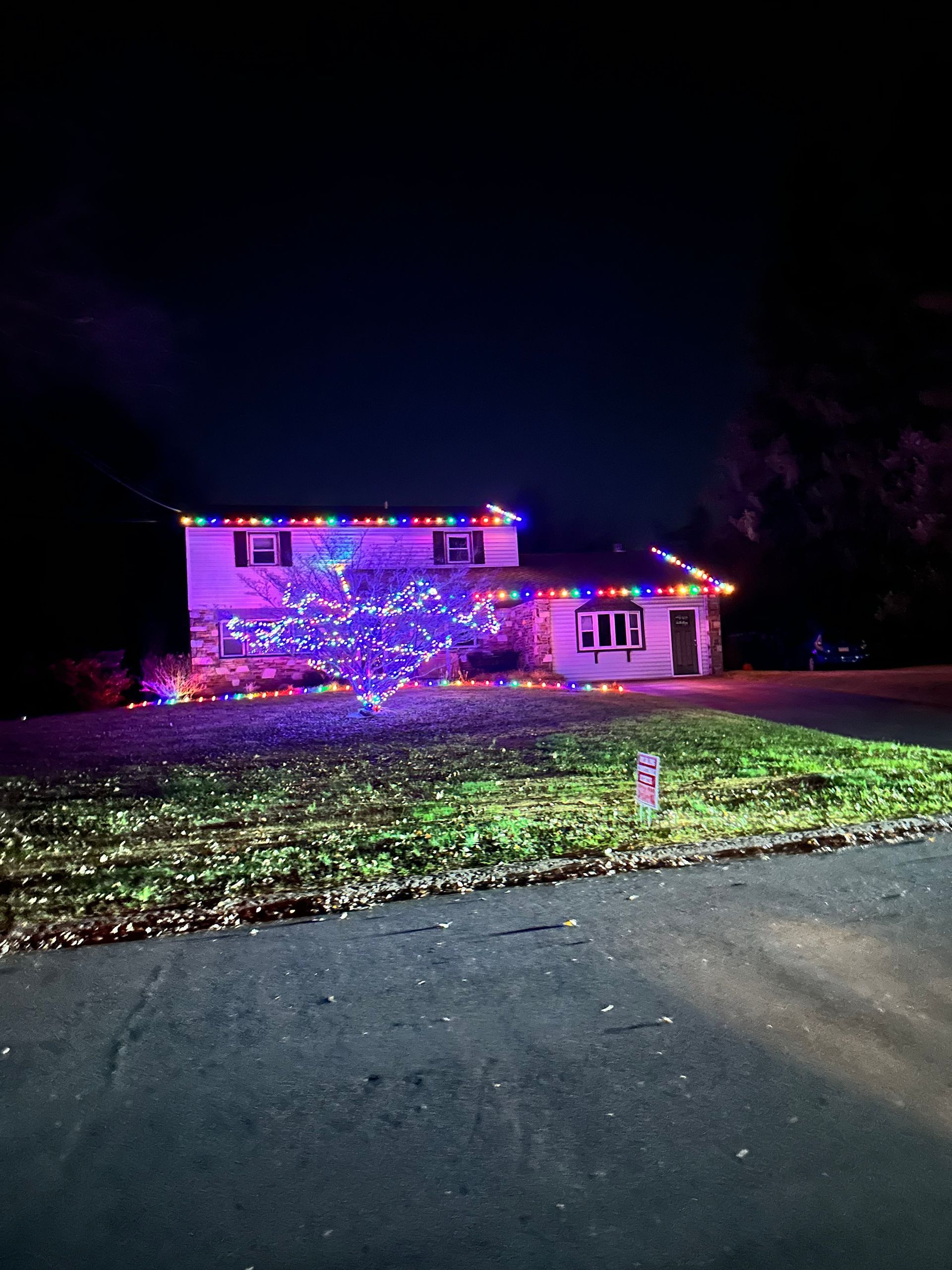 A house is decorated with christmas lights at night.