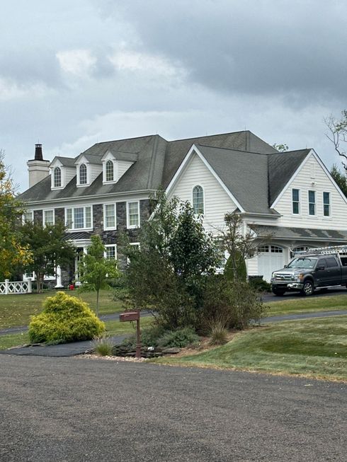 A large white house with a dirty roof.