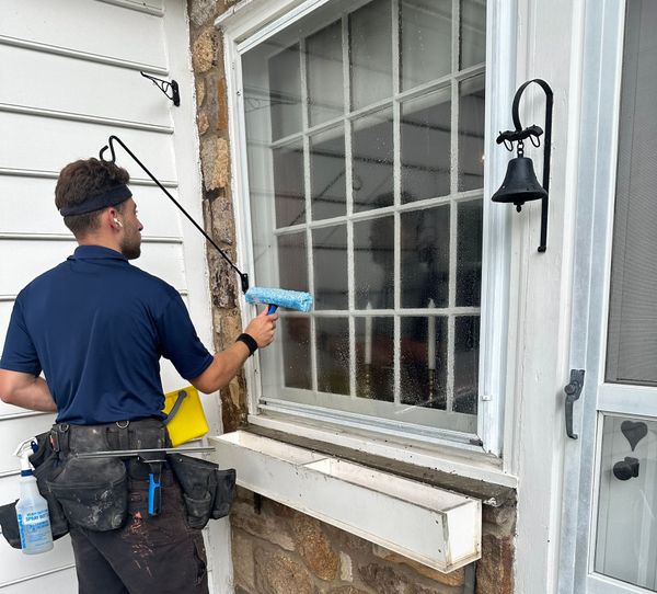 A man is cleaning a window with a squeegee