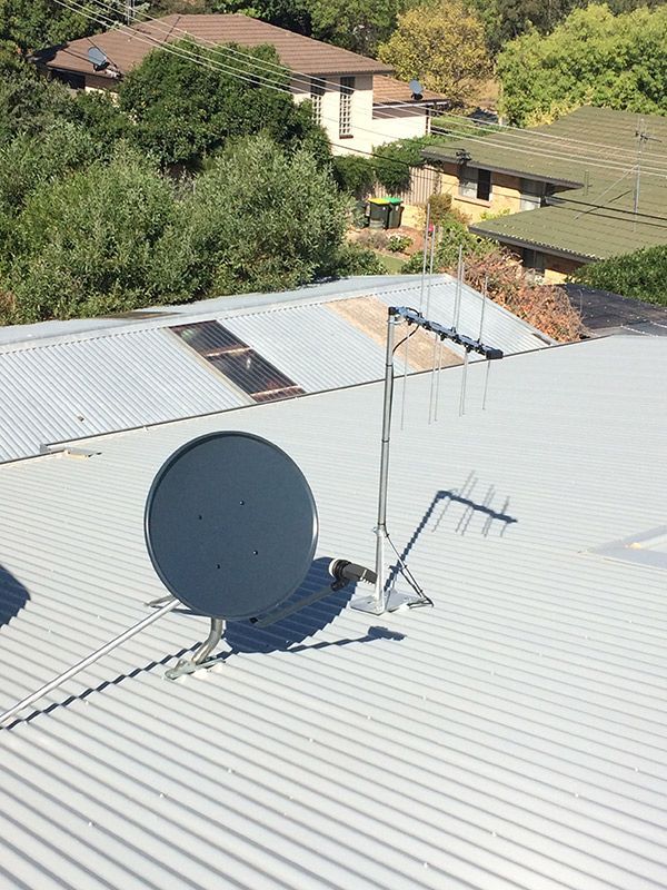 Satellite Dish And Antenna Is Sitting On Top Of A Metal Roof — Telecommunication Company In Belconnen, ACT