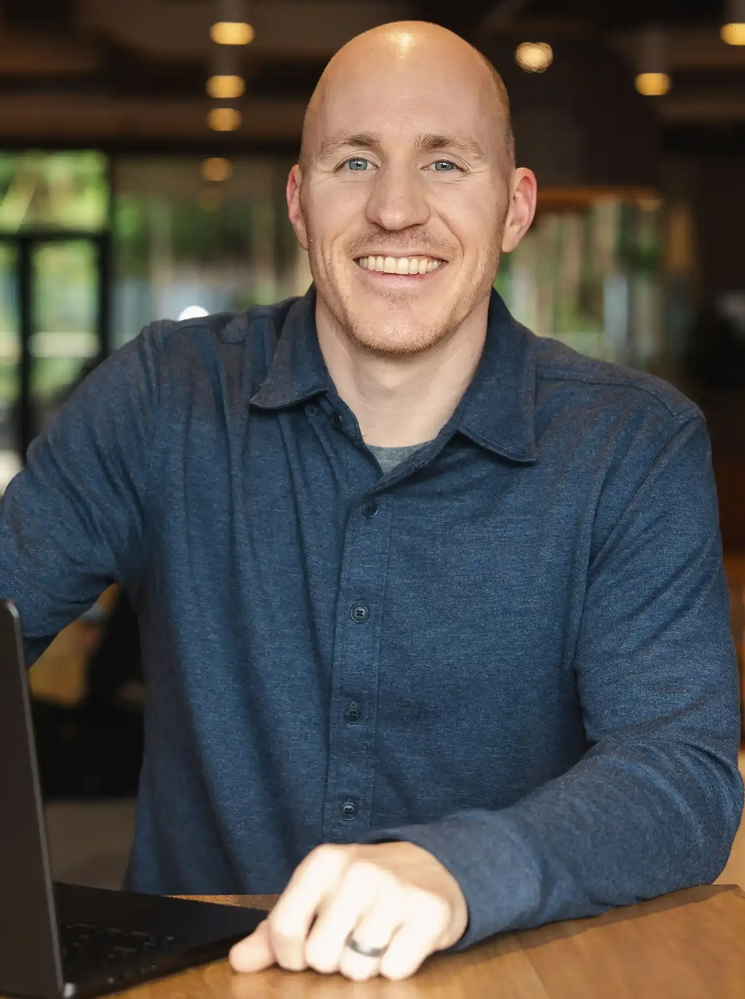 Career Coach Adam Broda Standing Next to Laptop Smiling