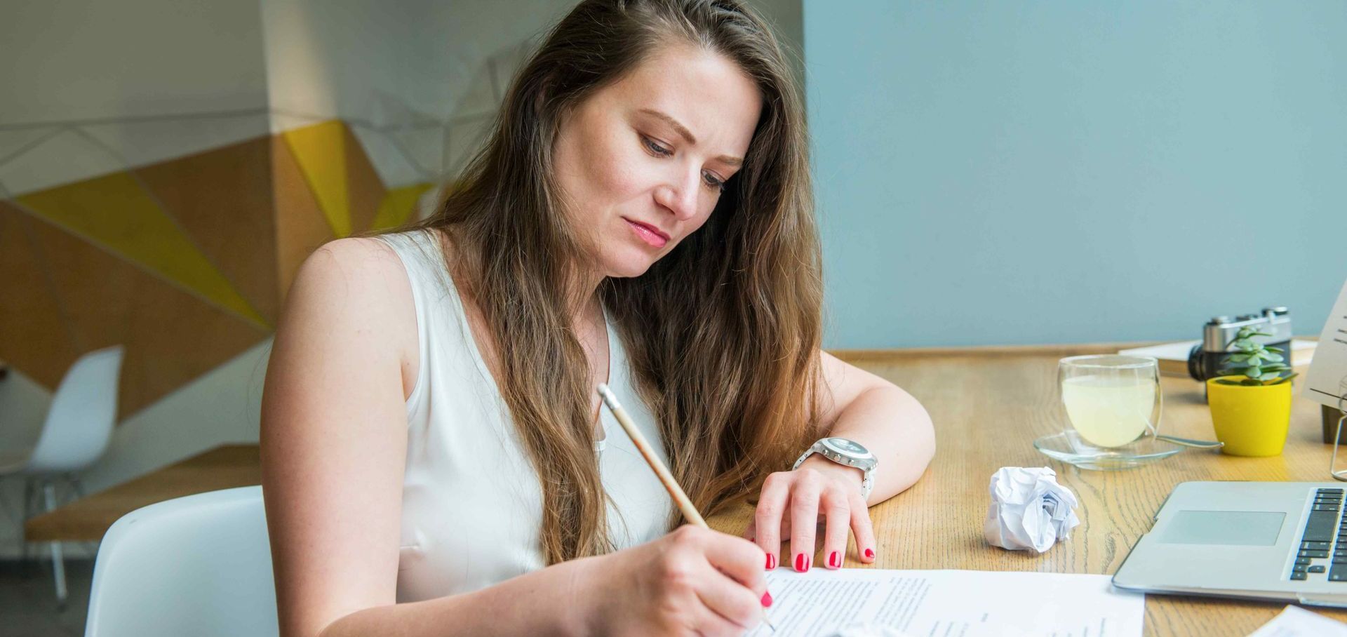 Professional Woman Writing Drafts of Personal Brand Statement at Desk