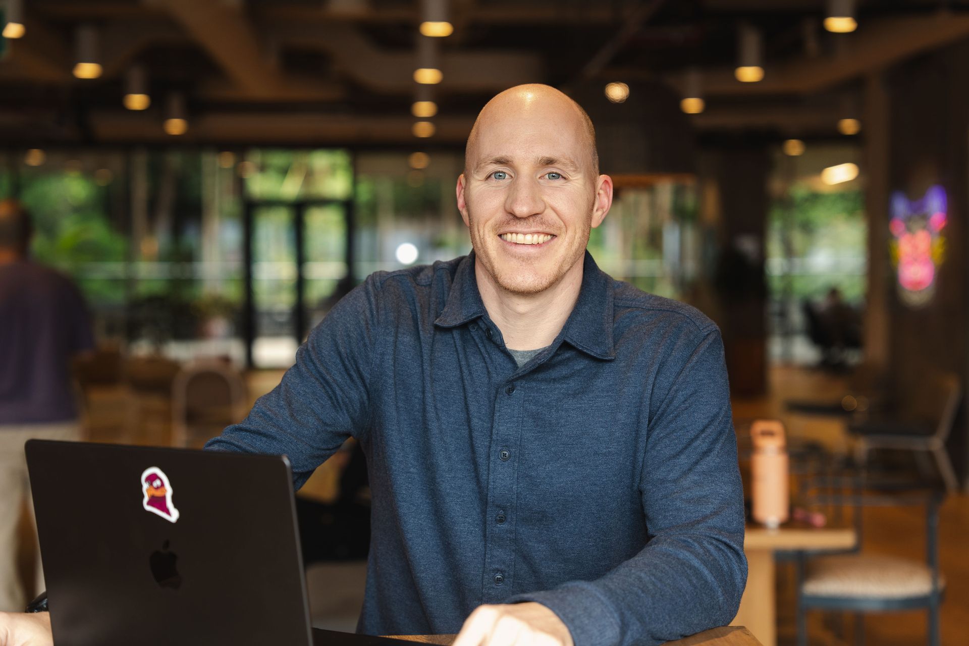 Career Coach Adam Broda Standing Next to Laptop Smiling