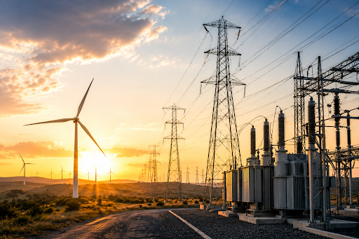 Wind turbines and electrical substation at sunset with power lines and transformers