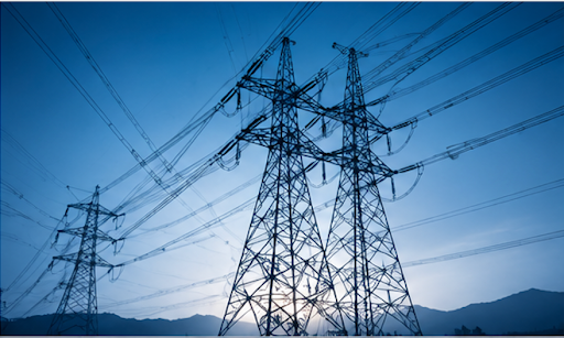 High-voltage power lines and transmission towers silhouetted against a blue dusk sky