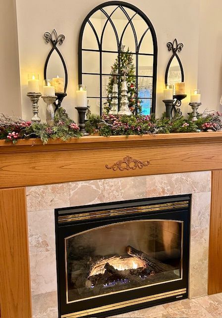 A fireplace with candles and a mirror on the mantle