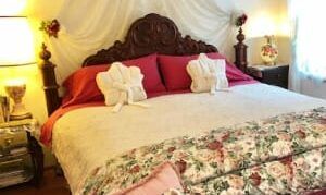 A bed with a floral comforter and pillows in a bedroom.