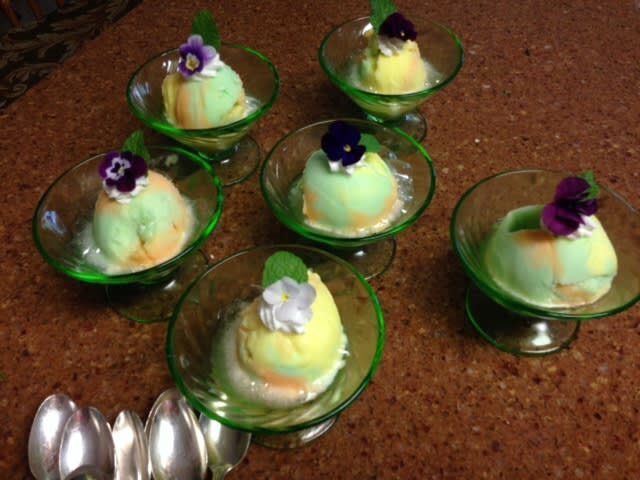 Ice cream in green bowls with spoons on a table