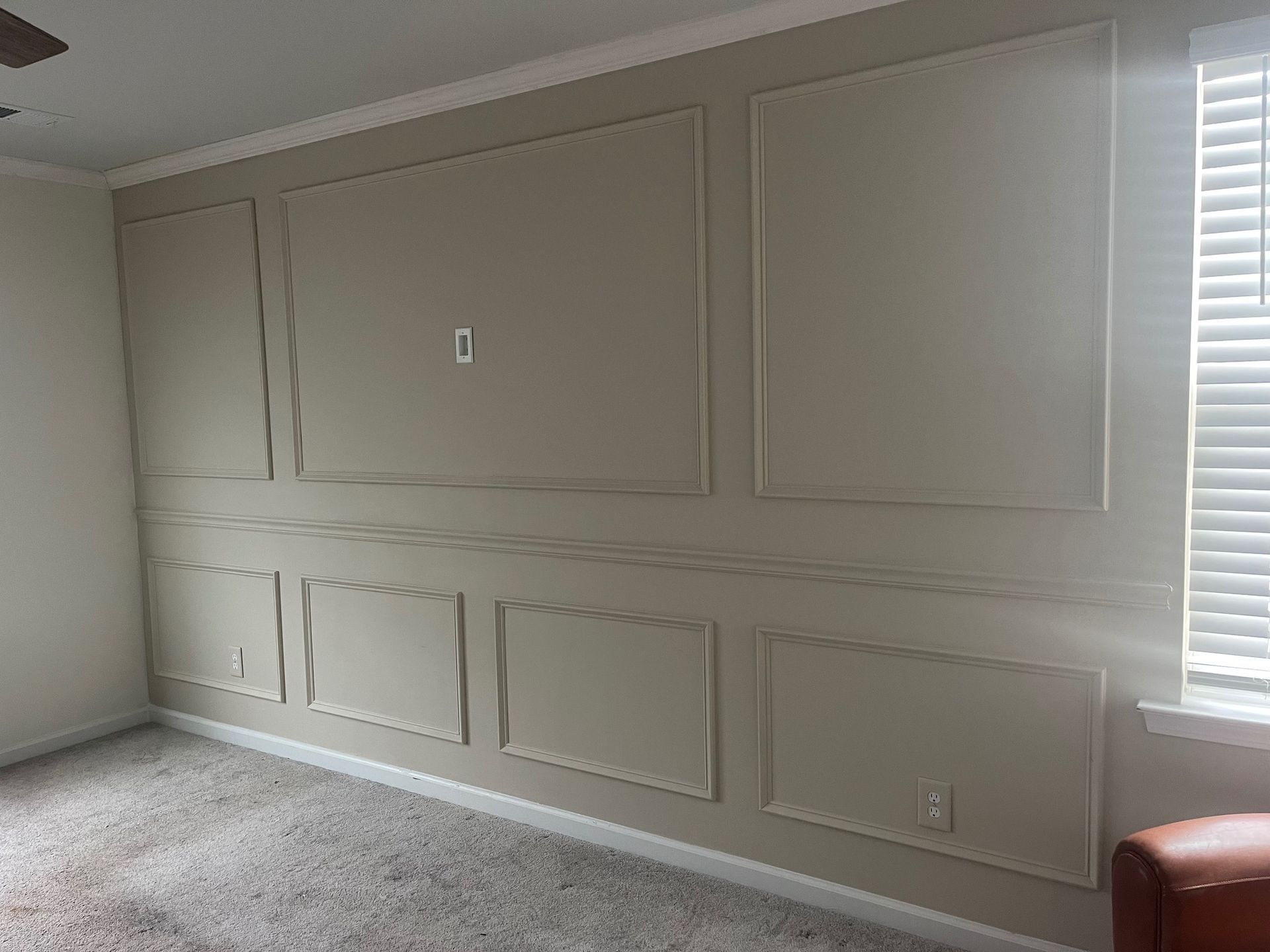 White panel molding on a wall with matching white wood flooring. White panel molding on a wall with matching white wood flooring.