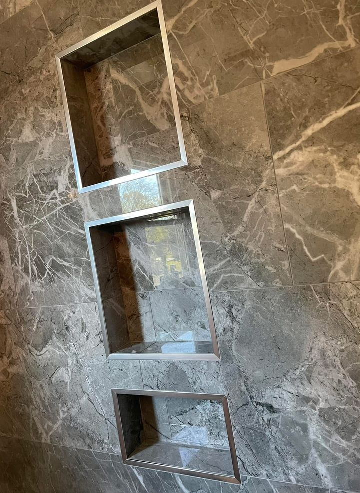 Interior under renovation with exposed wall studs, debris, and a staircase in the background