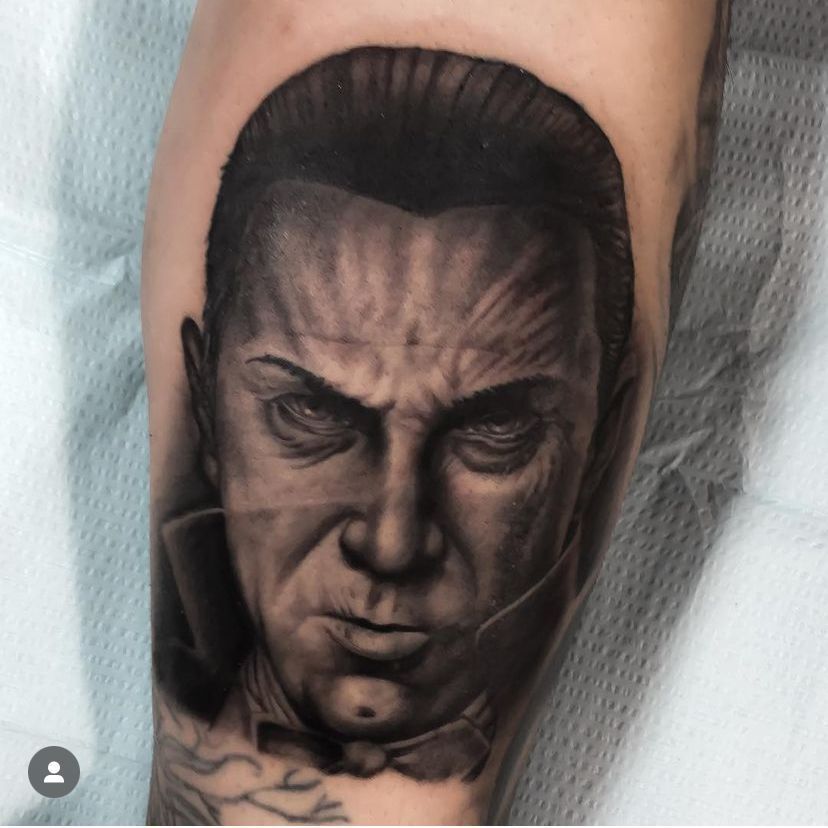 Black-and-gray tattoo of a stern Frankenstein-like face on skin