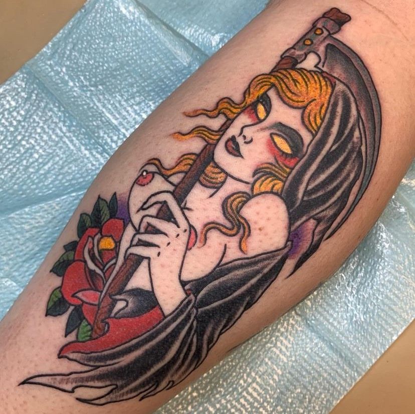 Black-and-red tattoo of a sleepy woman with flowing hair and roses on a forearm