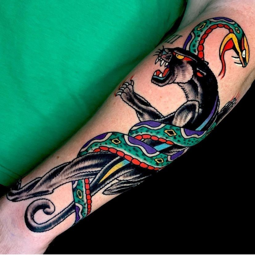 Colorful snake tattoo wrapped around a black panther on a forearm