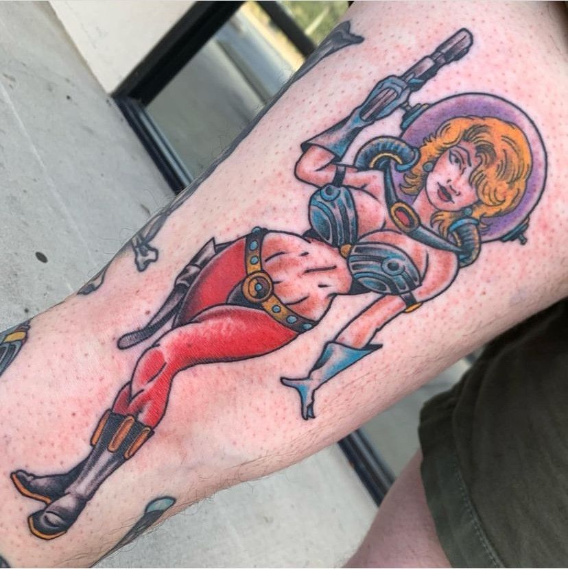 Colorful tattoo of a blonde armored female warrior with a sword on a forearm