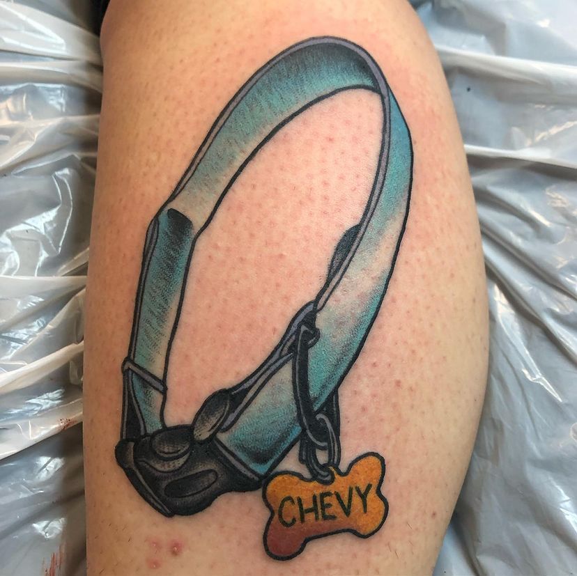 Black dog collar tattoo with an orange Chevy tag on skin.