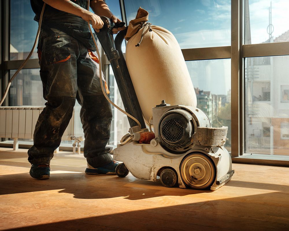 Wood floor sanding in Charlotte, NC by Larry Helms Floor Sanding & Refinishing Inc., using a heavy-duty floor sander.