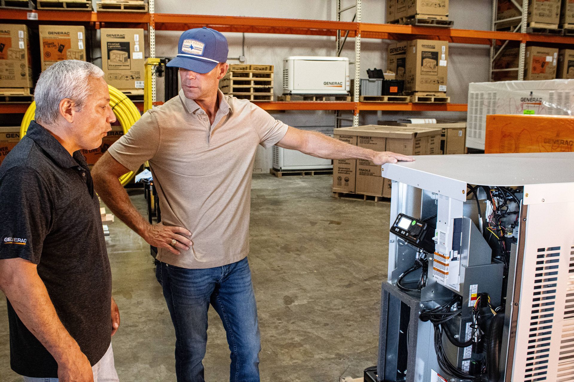 Two technicians at Premier Generators of Texas are inspecting a generator that needs repairing