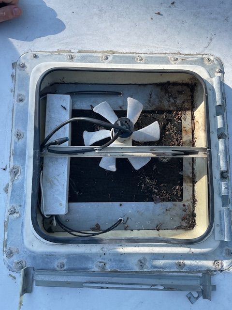 A fan is sitting inside of a roof vent.