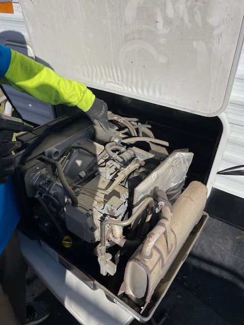 A person is looking under the hood of a vehicle