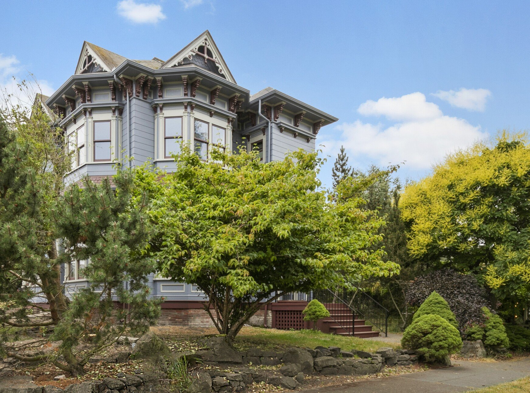 a large house with a lot of windows is surrounded by trees and bushes .