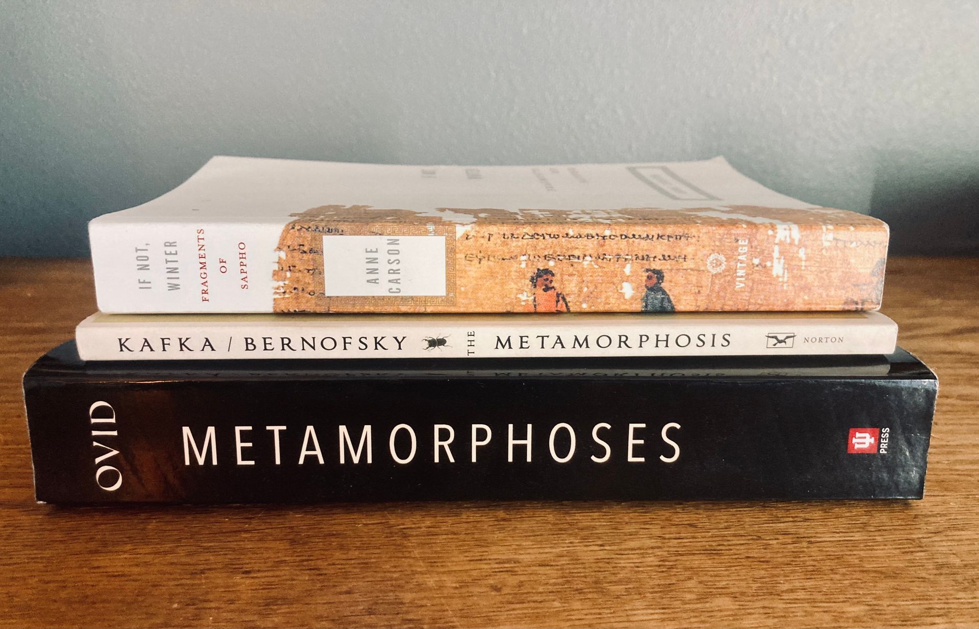 Three books stacked on top of each other including metamorphoses