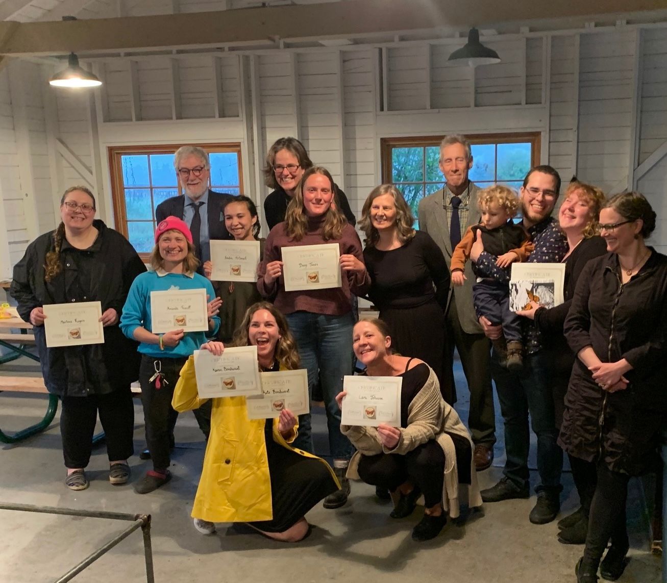 A group of people posing for a picture holding papers