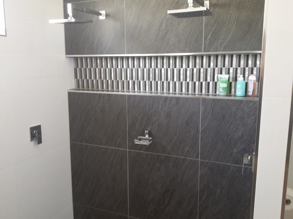 Modern shower installation with dual showerheads and stylish tile design