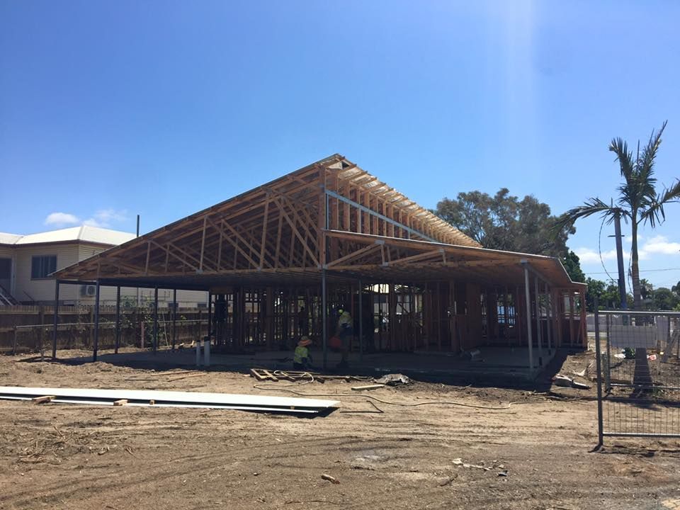 Building construction site with wooden framing and workers on site