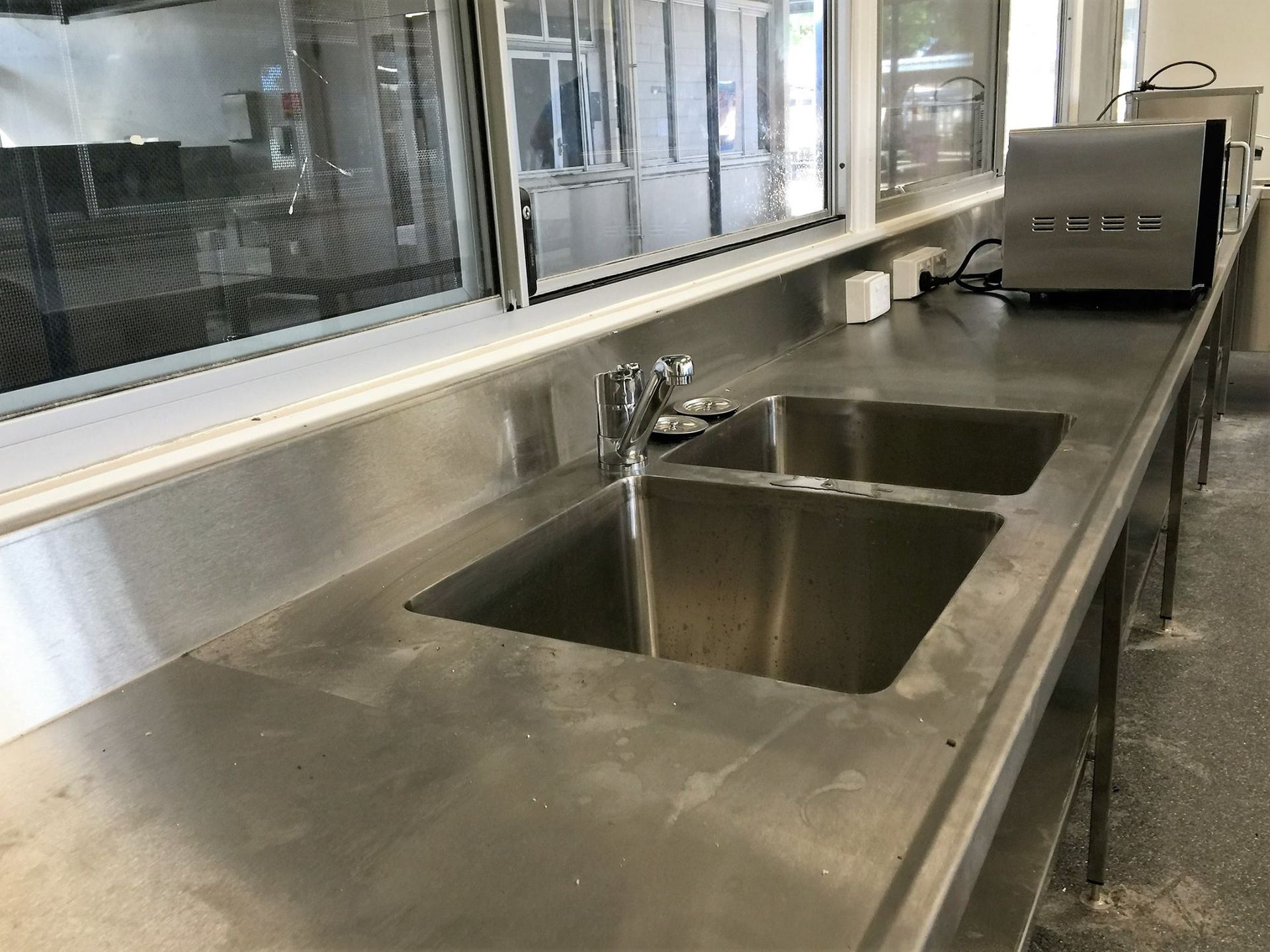 Commercial kitchen sink with stainless steel countertops and appliances