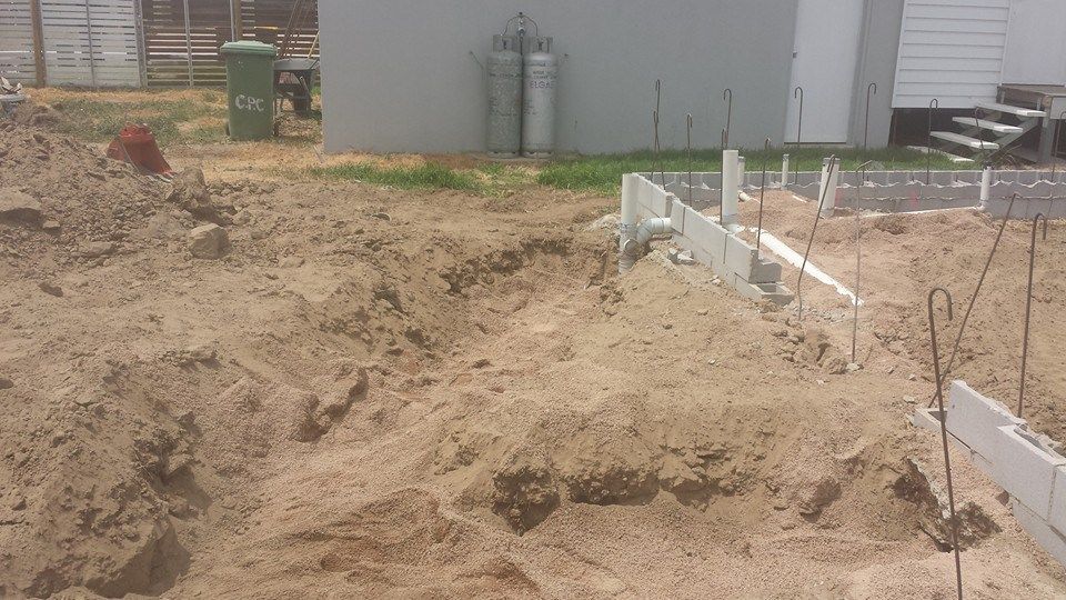A pile of dirt is sitting in front of a building.