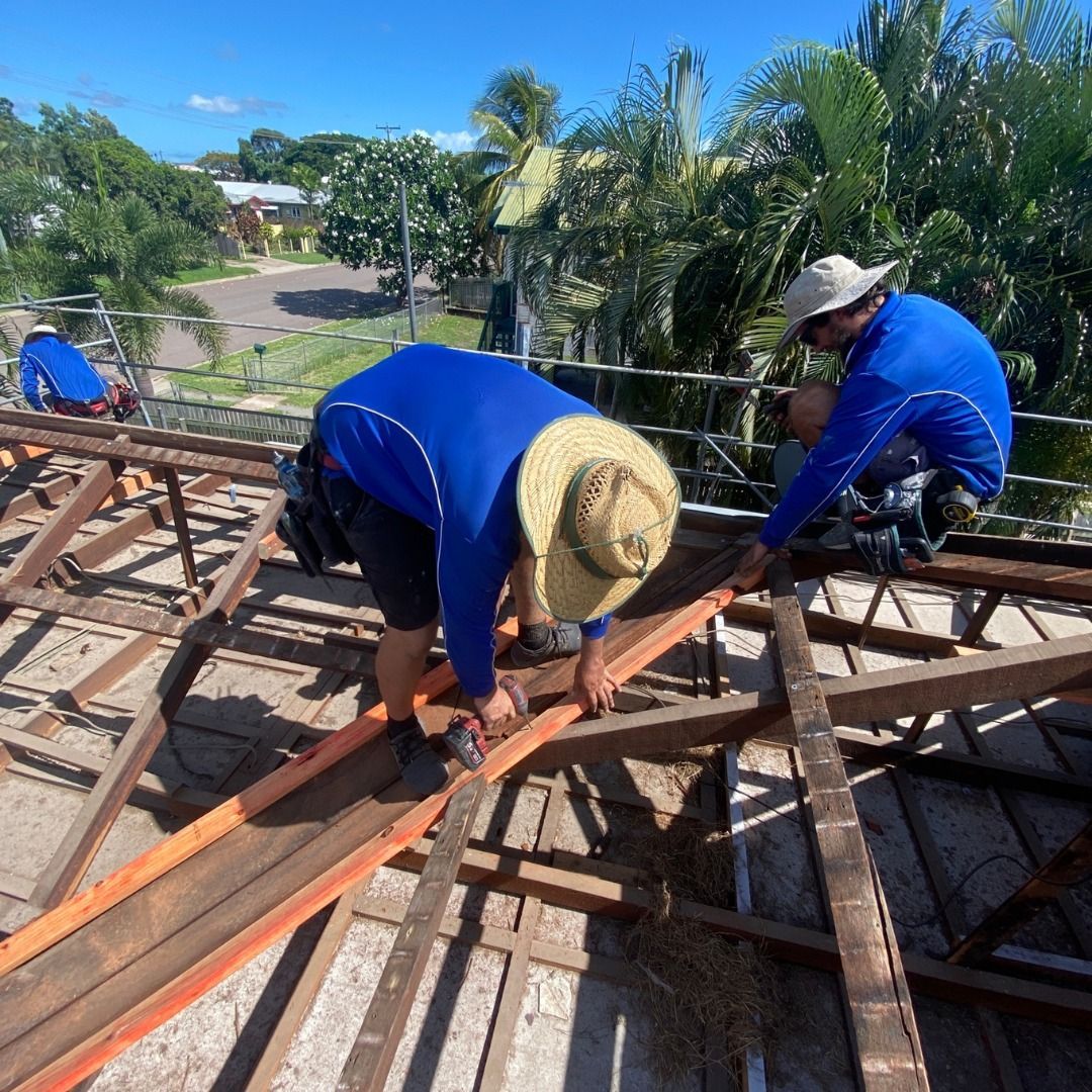 Two men wearing hats are working on a wooden structure
