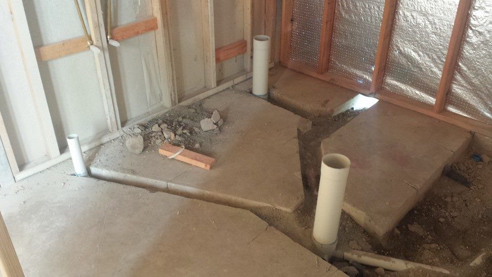 Plumbing pipes installed in a concrete slab during construction