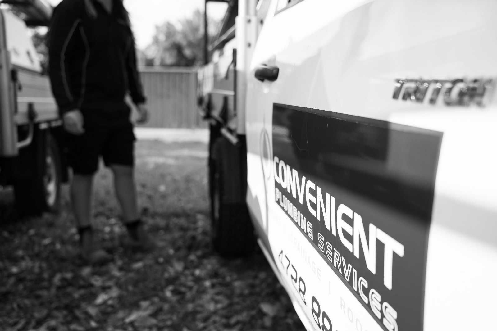 A plumber stands near a service truck with